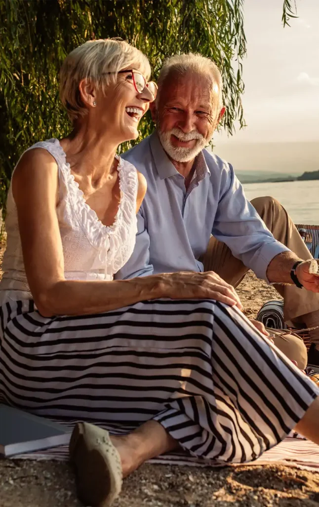 retired couple enjoying a picnic on the beach retirement future